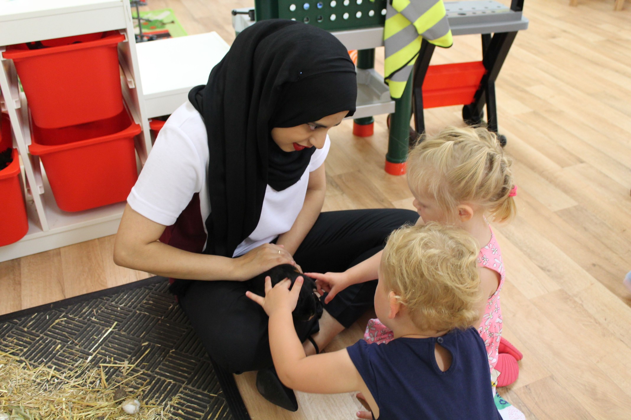 Saliha using the nursery guinea pig to teach the children different concepts and vocabulary.